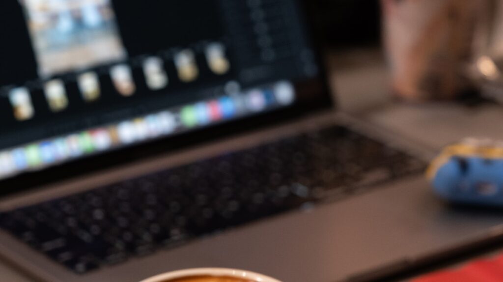 Bureau avec ordinateur portable et café, création de site internet déléguée