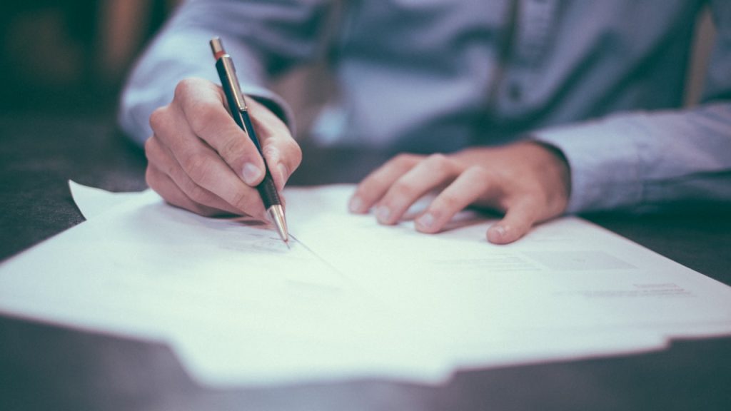 Personne relisant et annotant un document : exemple de CGU à adapter à son site internet