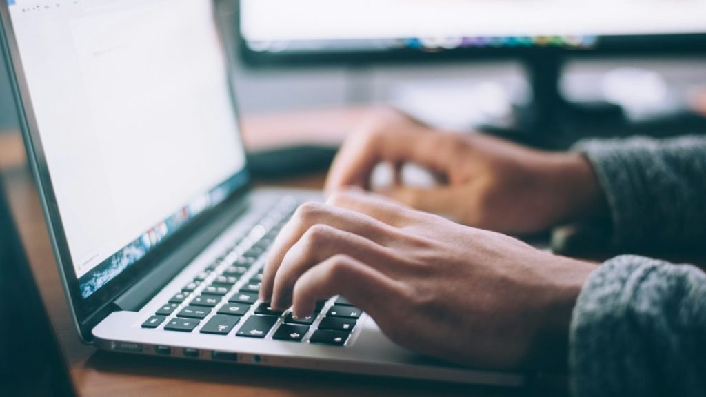 Dirigeant de TPE qui vérifie le registrar de son nom de domaine sur un ordinateur portable